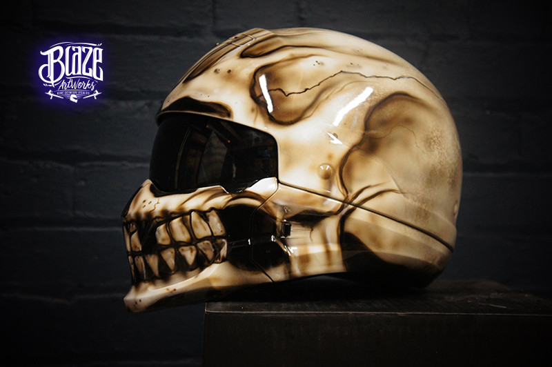 Bone-colored motorcycle helmet with photorealistic human skull airbrush design featuring anatomical details and crack effects